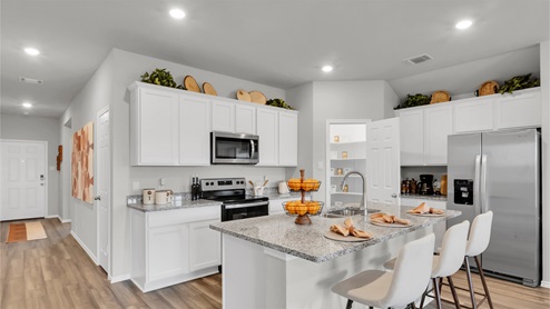 Eastern Wells Model Home kitchen with white cabinets and decorative accent pieces.