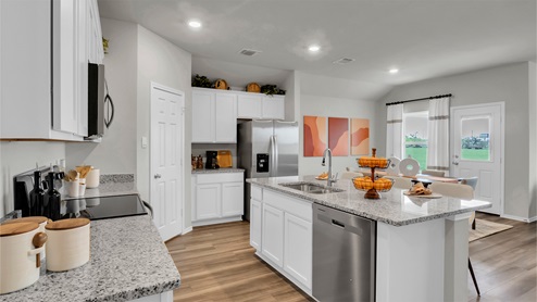 Eastern Wells Model Home kitchen with vinyl plank flooring and center island and undermount sink.