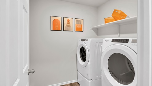 Eastern Wells Model Home utility room with front load washer and dryer.