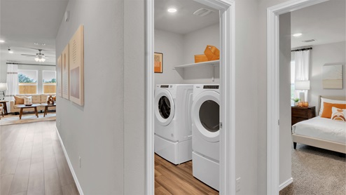 Eastern Wells Model Home utility room with front load washer and dryer.