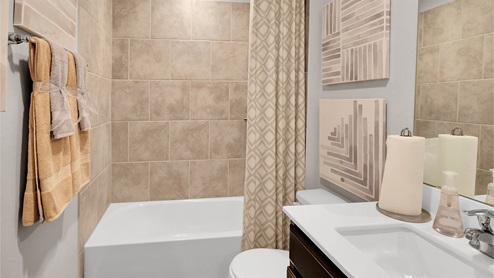 Eastern Wells Model Home secondary bathroom with tub and shower combination with ceramic tile surround.