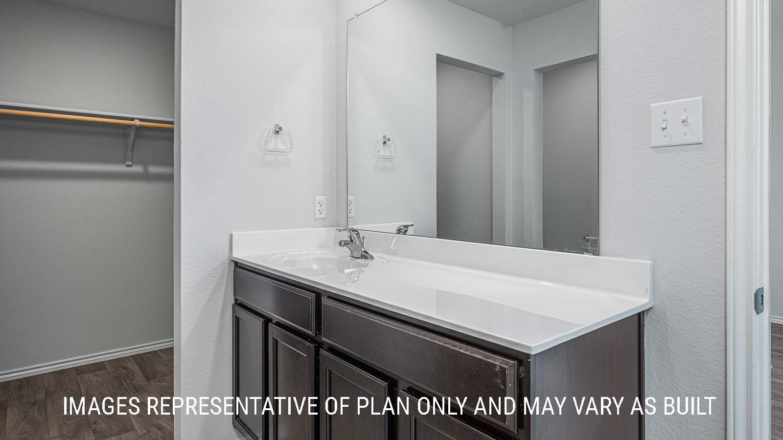 Elgin primary bathroom with single vanity sink and view of primary closet.
