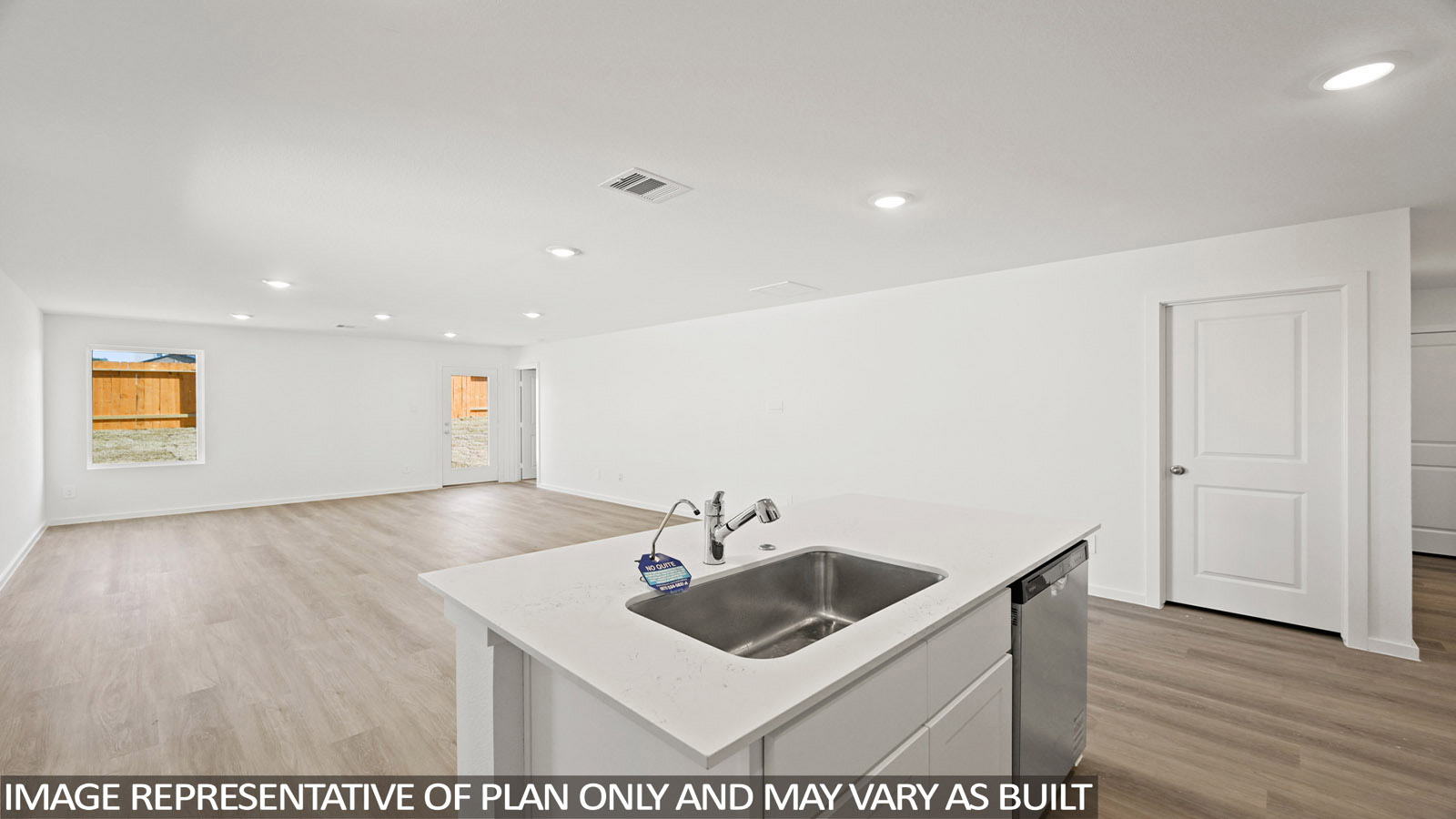 Callahan kitchen with kitchen island with light countertops and view of living room.