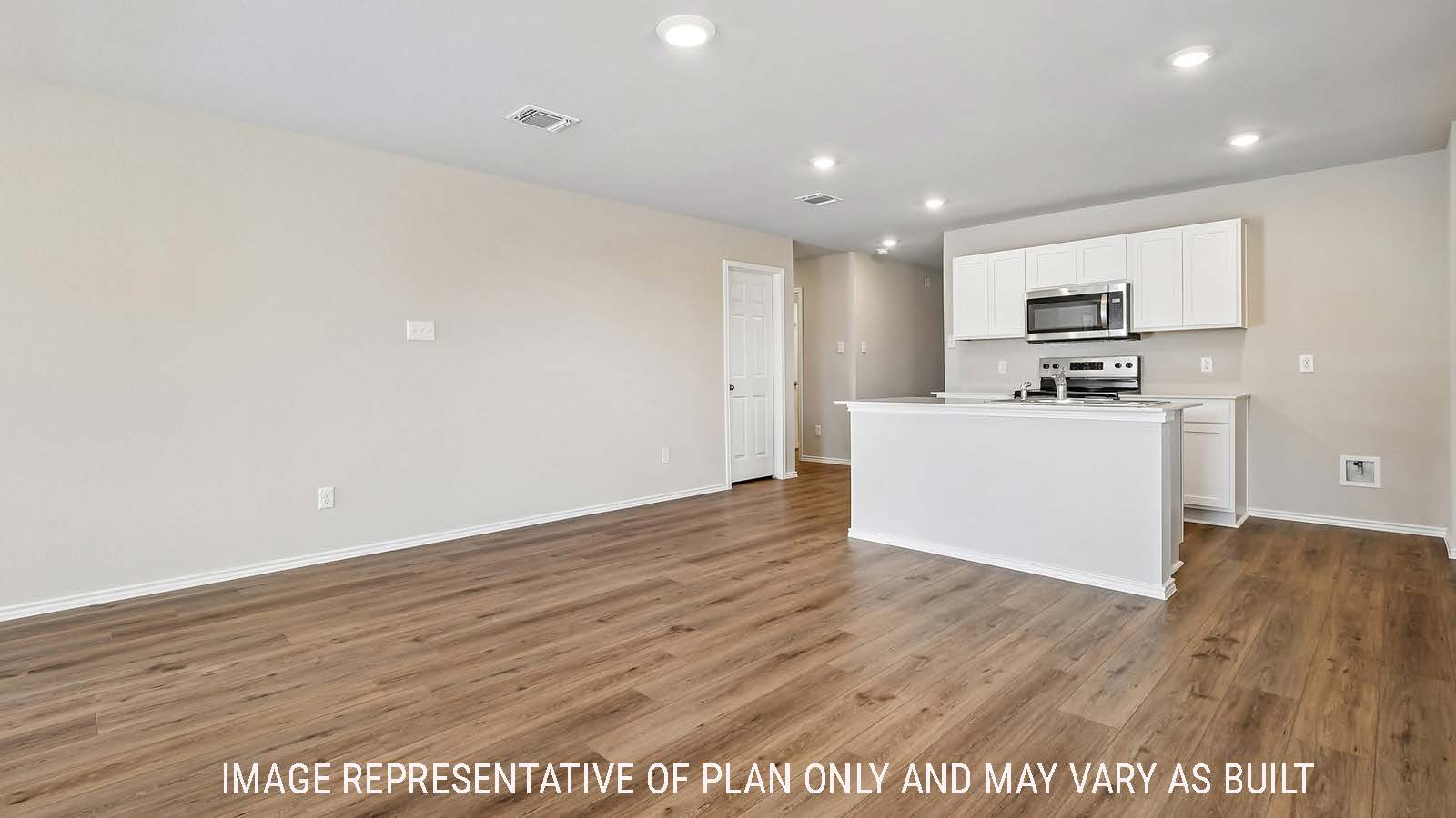 Callahan dining room with view of open concept kitchen with kitchen island and light cabinets.