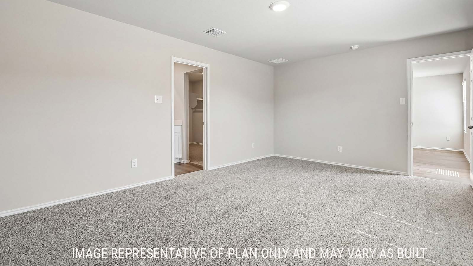 Callahan primary bedroom with carpeted flooring and view of primary bathroom.