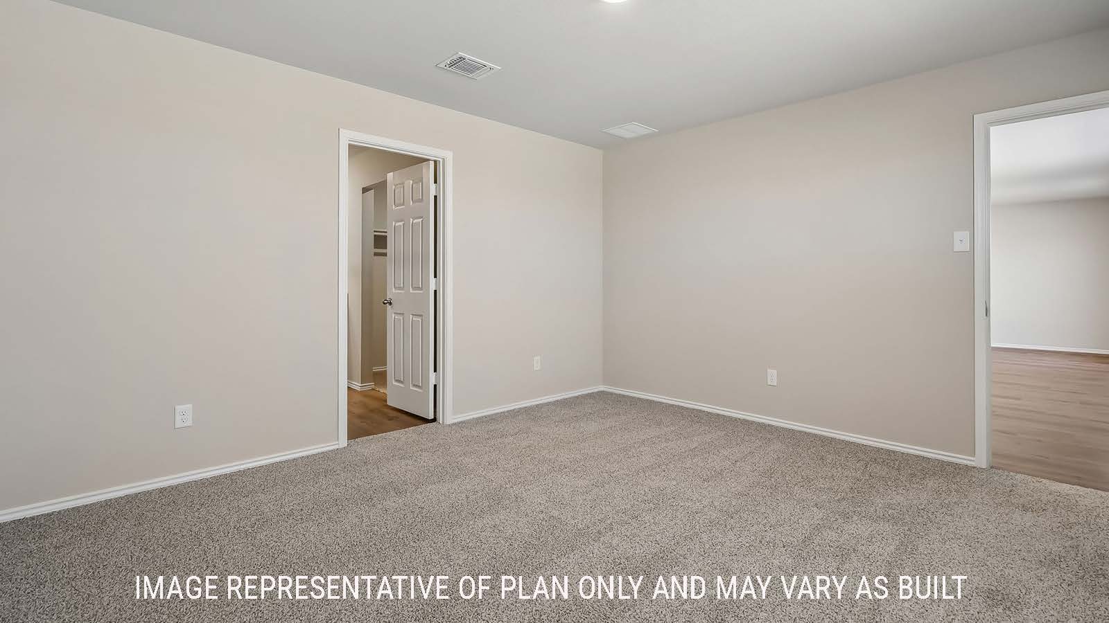 Austin primary bedroom with carpeted flooring and view of primary bathroom.