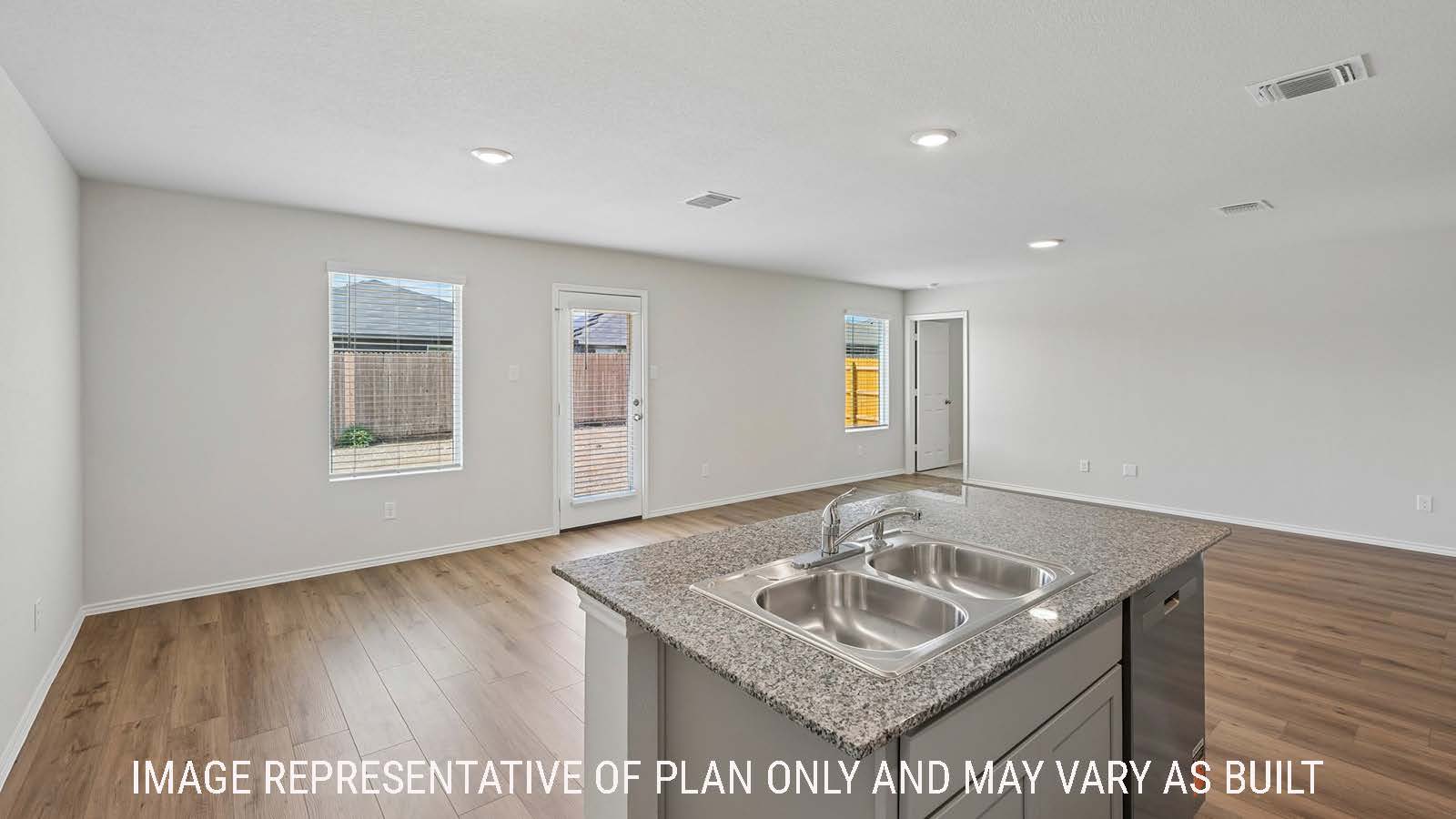 Baird kitchen with kitchen island with granite countertops and view of open concept dining room and living room.