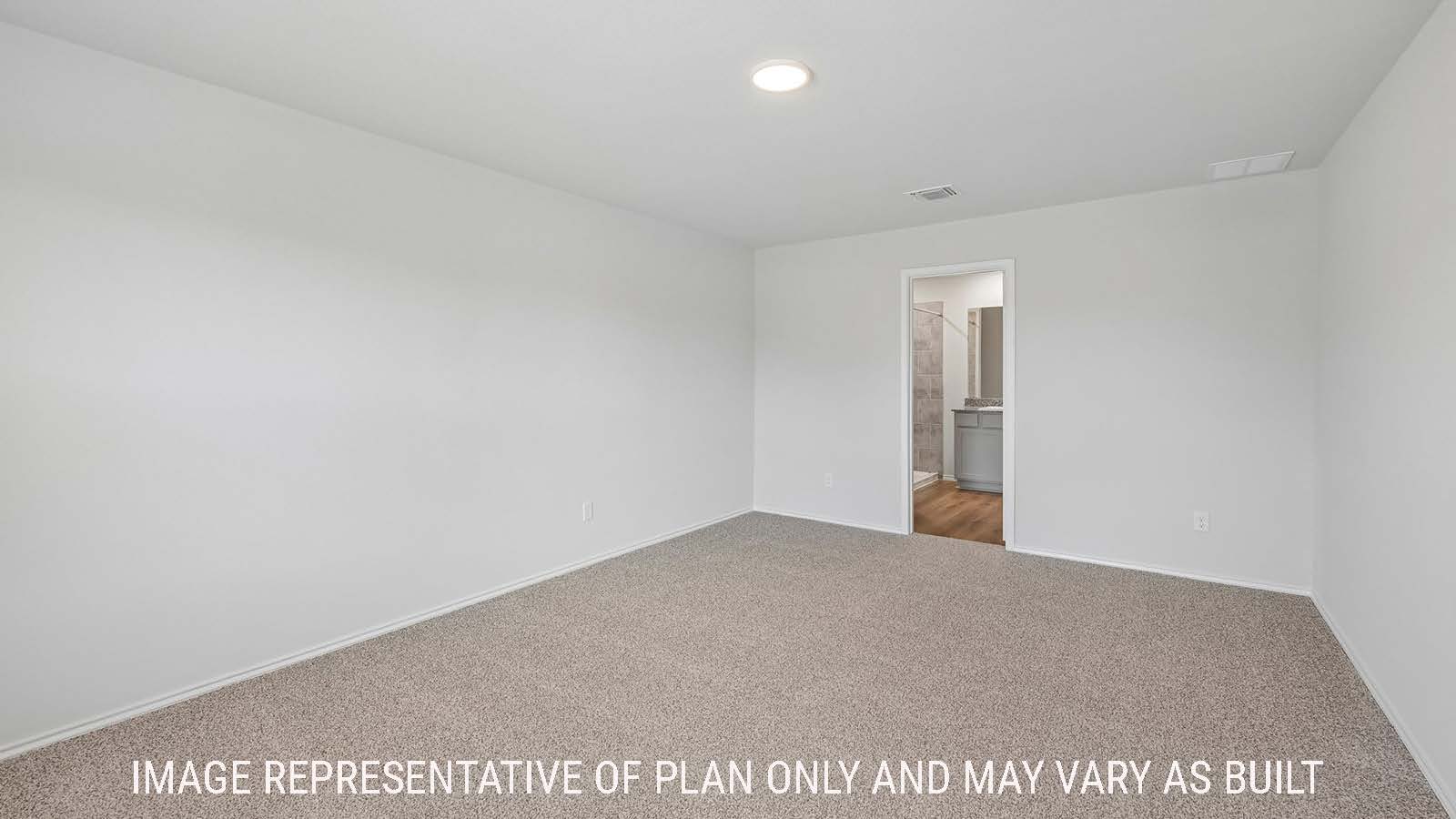 Baird primary bedroom with carpeted flooring and view of primary bathroom.