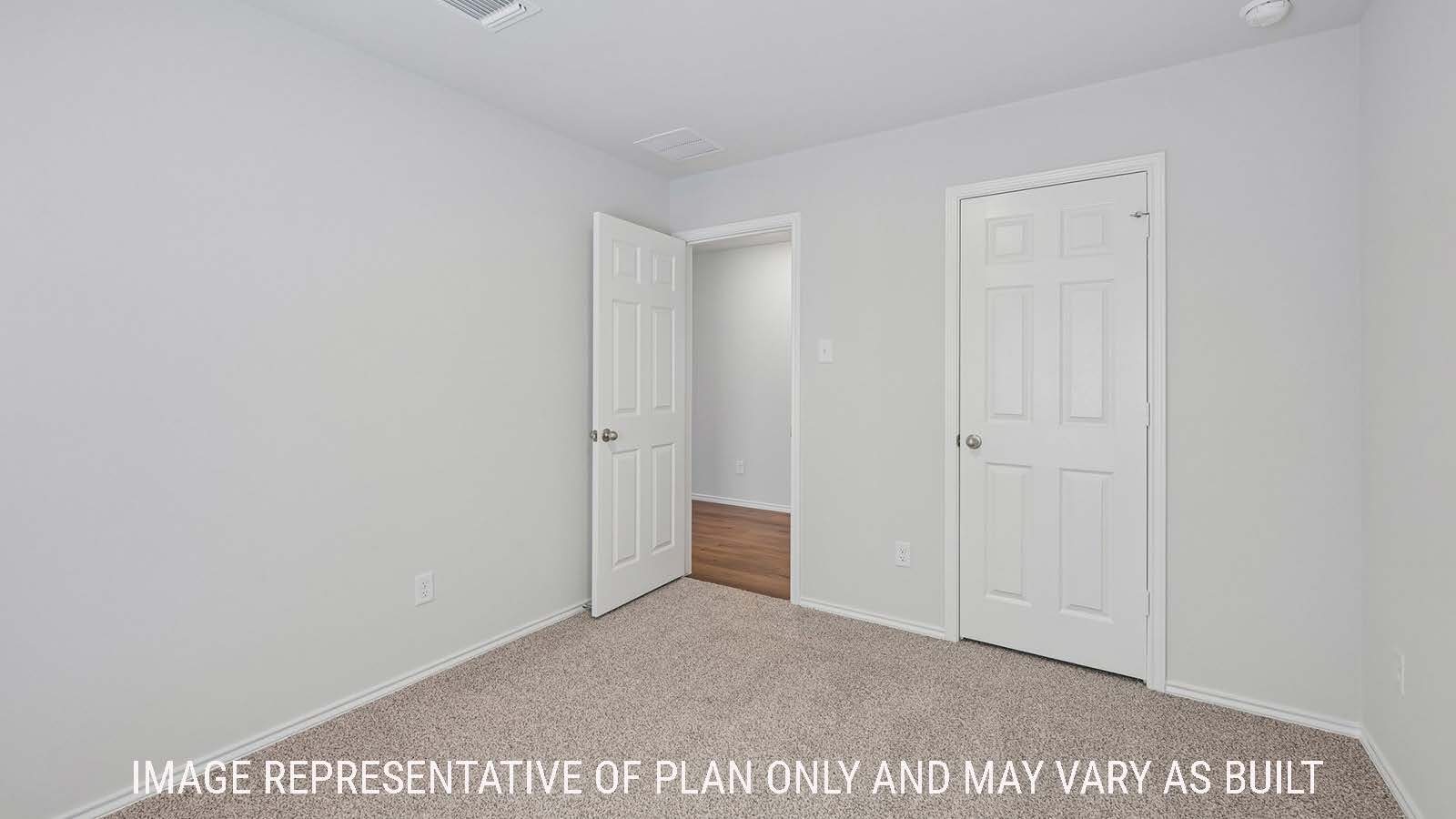 Baird secondary bedroom with carpeted flooring and view of hallway.