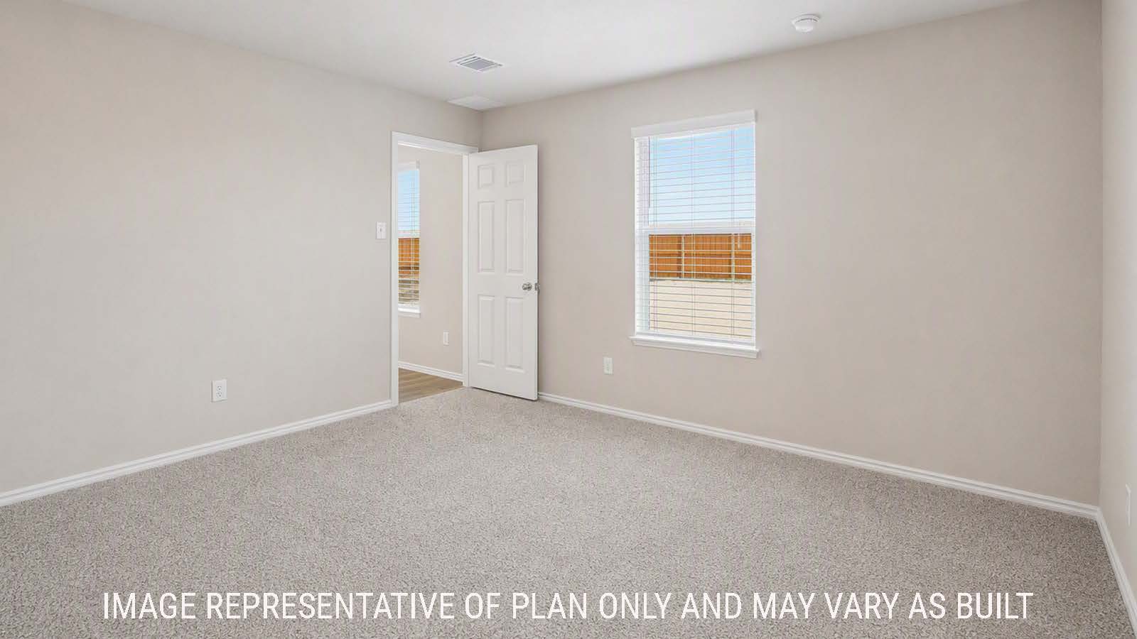 Denise primary bedroom with carpeted flooring and windows for natural lighting.