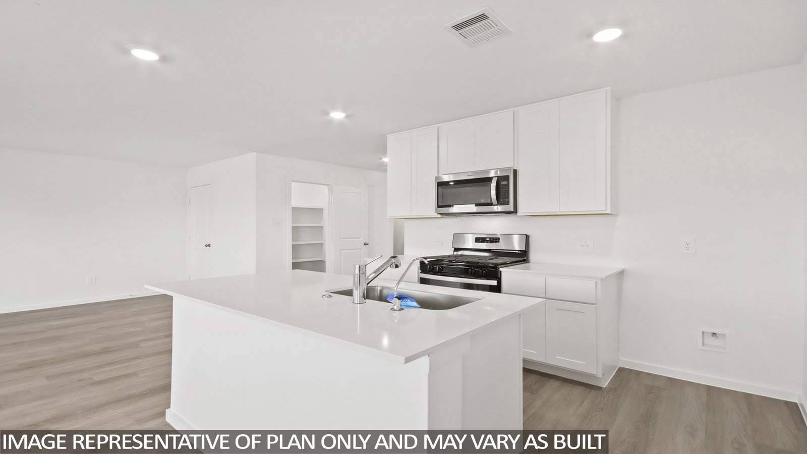 Denise kitchen with kitchen island with light cabinets and light countertops.