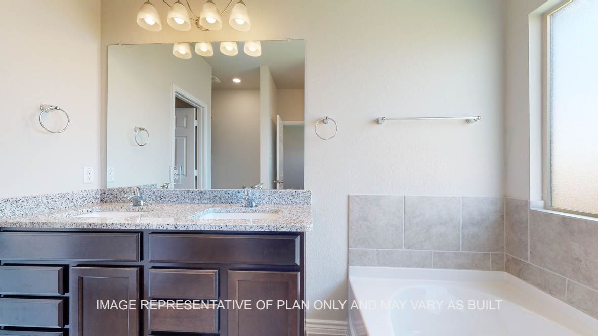 Elmwood primary bathroom with dual vanities and granite countertops.