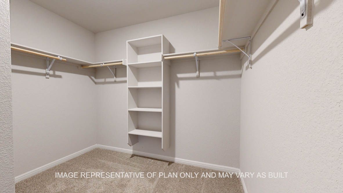 Elmwood primary bedroom walk-in closet with carpet flooring.