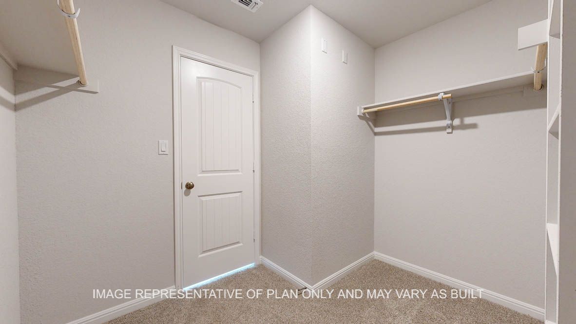 Elmwood primary bedroom walk-in closet with carpet flooring.