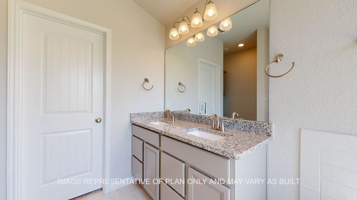 Elmwood primary bathroom with granite countertops and light cabinets.