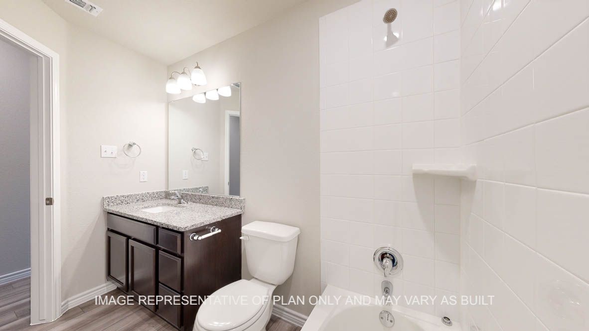 Elmwood secondary bathroom with single vanity and granite countertops.