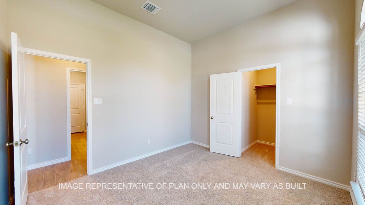 Sierra secondary bedroom with carpet flooring and walk-in closet.