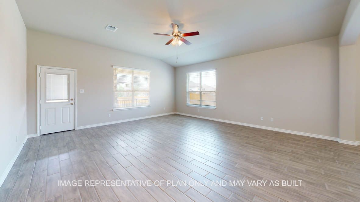 Sierra living room with wood look tile flooring and ample windows for natural lighting.
