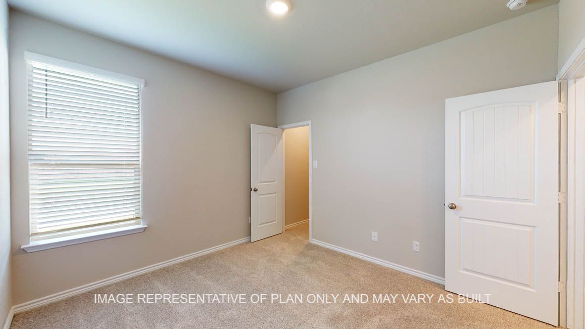 Sierra secondary bedroom with carpet flooring and walk-in closet.