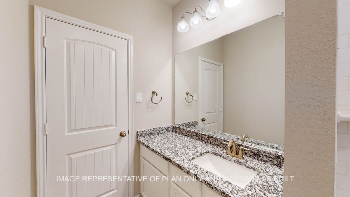 Sierra secondary bath with granite countertops and white cabinets.