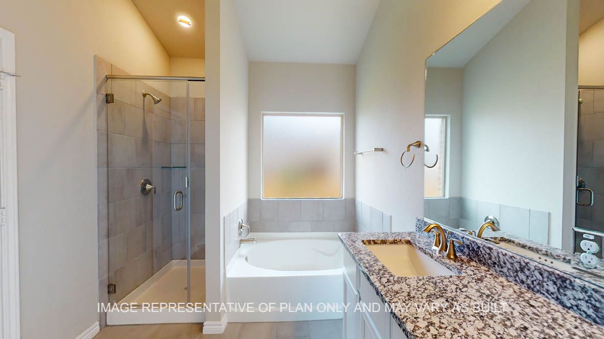 Sierra primary bath with separate tun and shower with granite countertops.