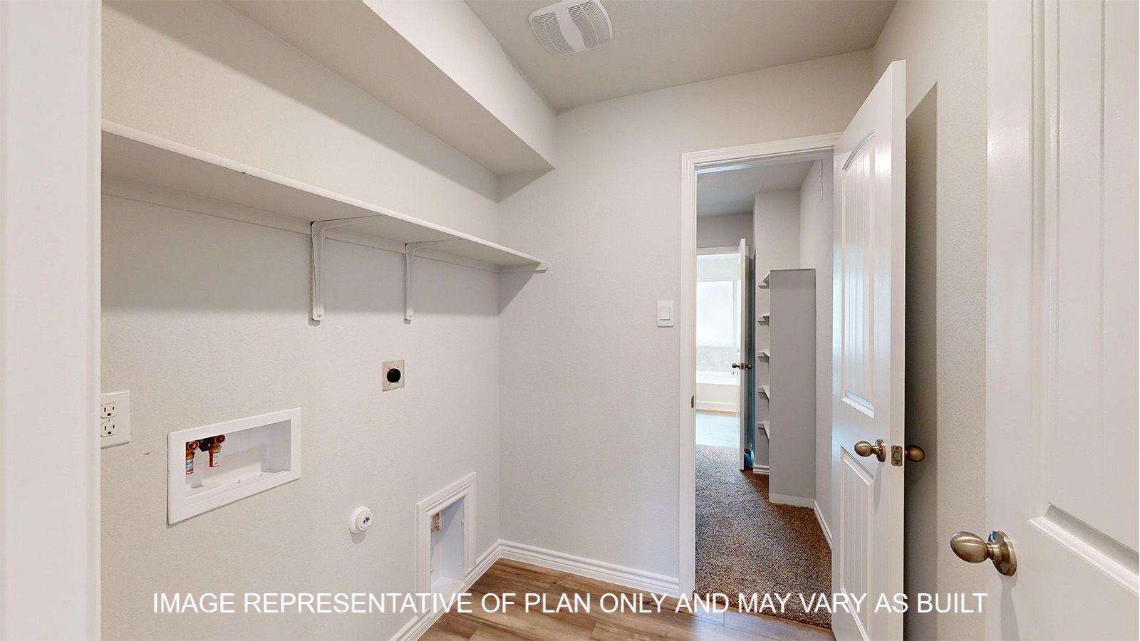 Magnolia utility room with storage shelf and vinyl plank flooring.