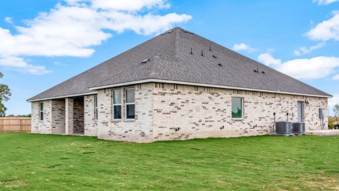Country Meadows model home backyard with brown wooden plank fence.