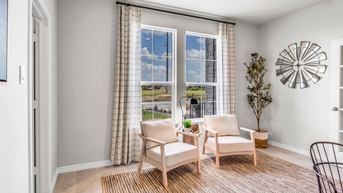 Country Meadows model home study staged with furniture and view of windows.