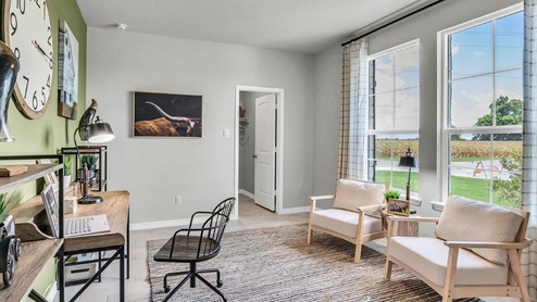 Country Meadows model home study with desk and accent chairs.
