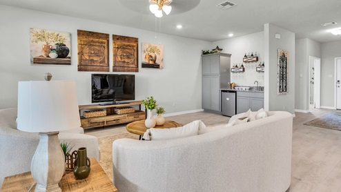 Country Meadows model home living room with view of the front door and secondary bedroom.