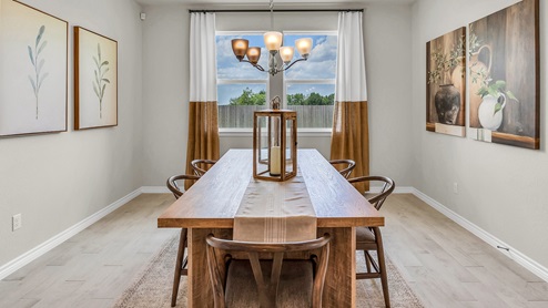 Country Meadows model home dining room with wood look tile and staged with furniture.