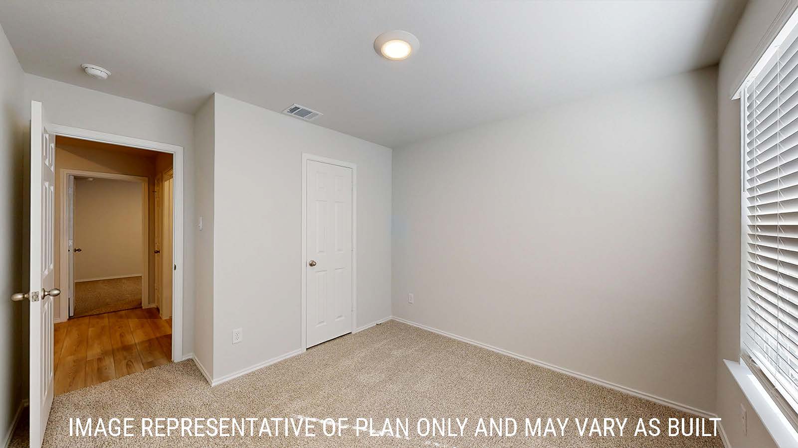 Harris secondary bedroom with carpeted flooring and view of hallway.