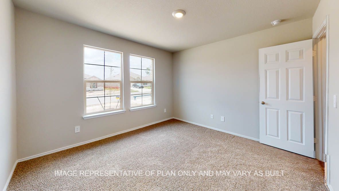 Elgin secondary bedroom with carpet flooring and windows.