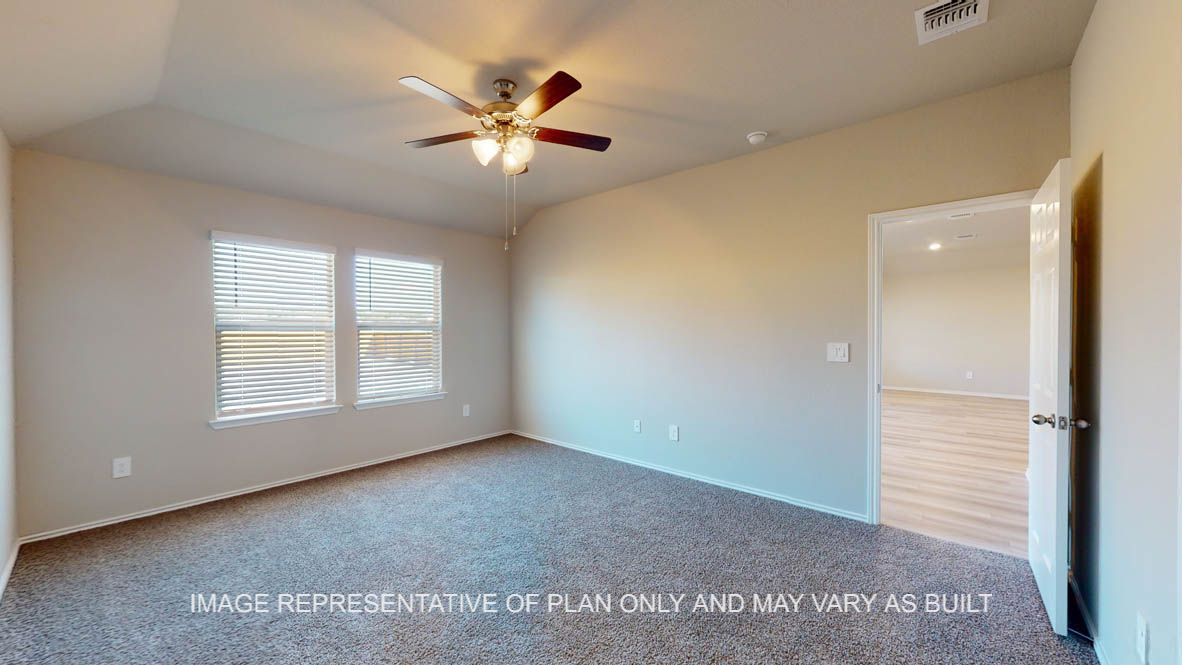 Texas Cali primary bedroom with carpet flooring and windows.