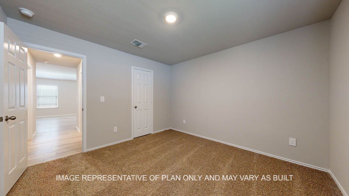 Seabrook secondary bedroom with carpet flooring and view into hallway.