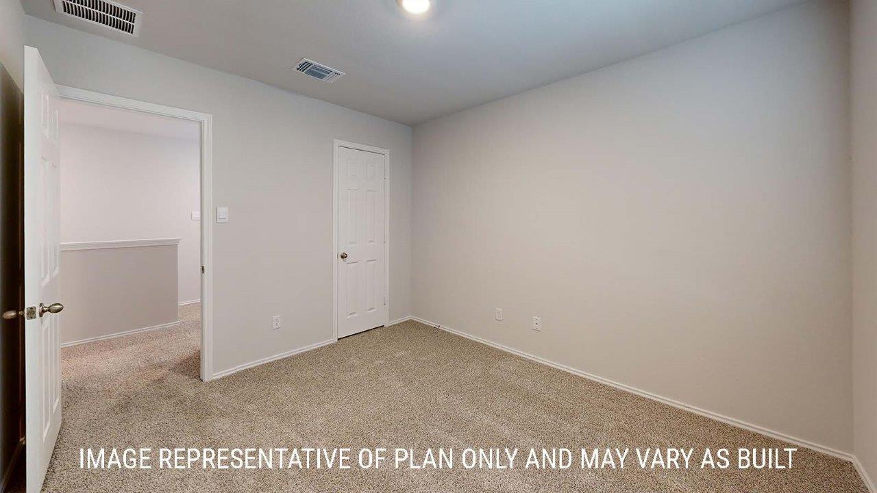 Emma secondary bedroom with carpeted flooring and closet.