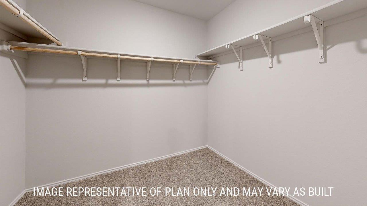 Emma primary closet with carpeted flooring and shelving for storage.