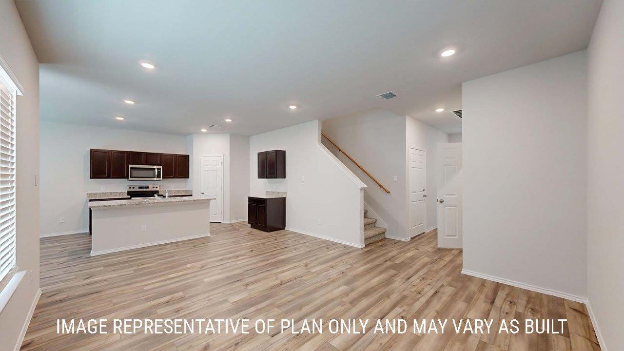 Emma living room with vinyl plank flooring and view of kitchen and entryway.