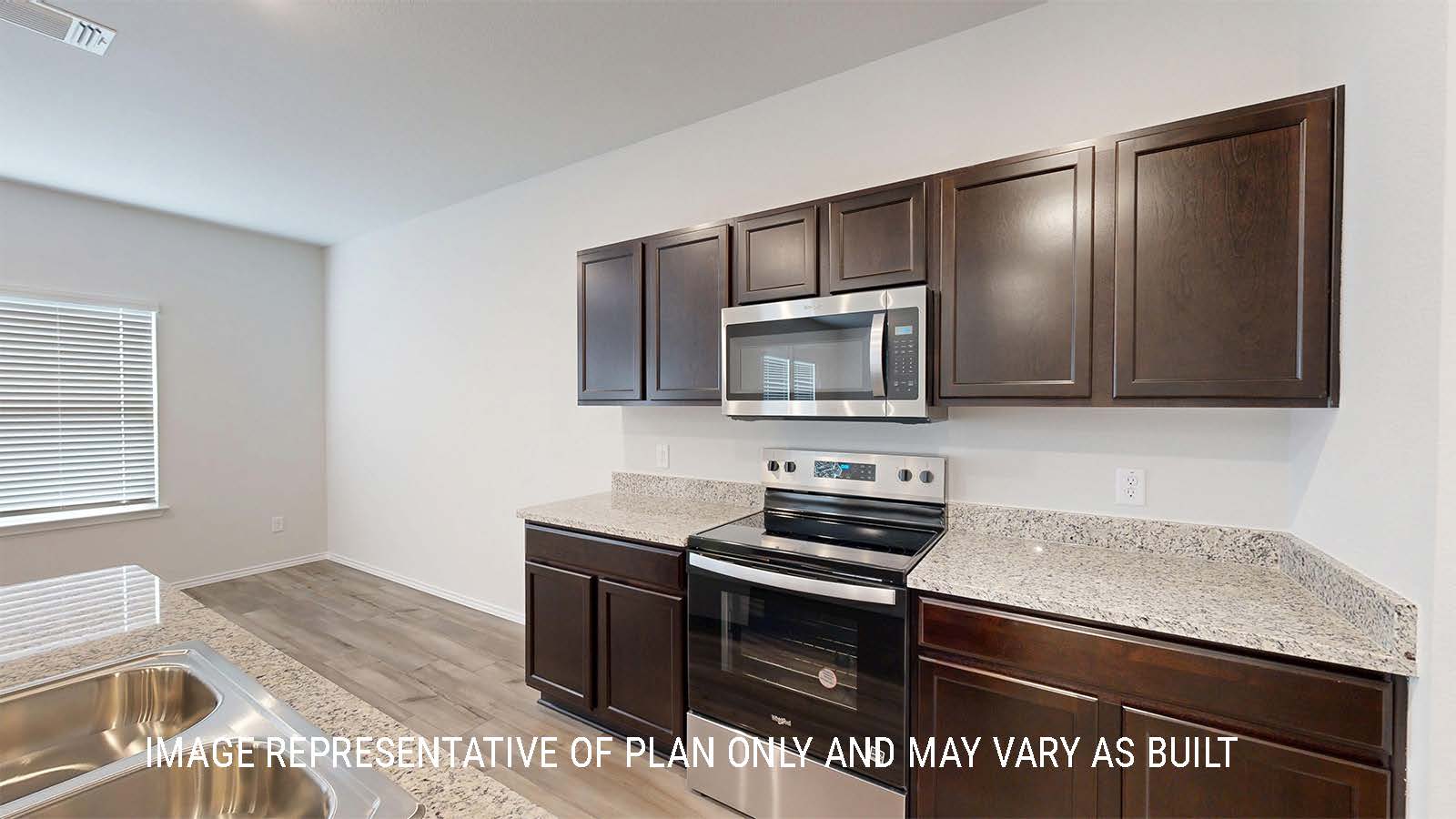 Grace kitchen with dark cabinets and granite countertops.
