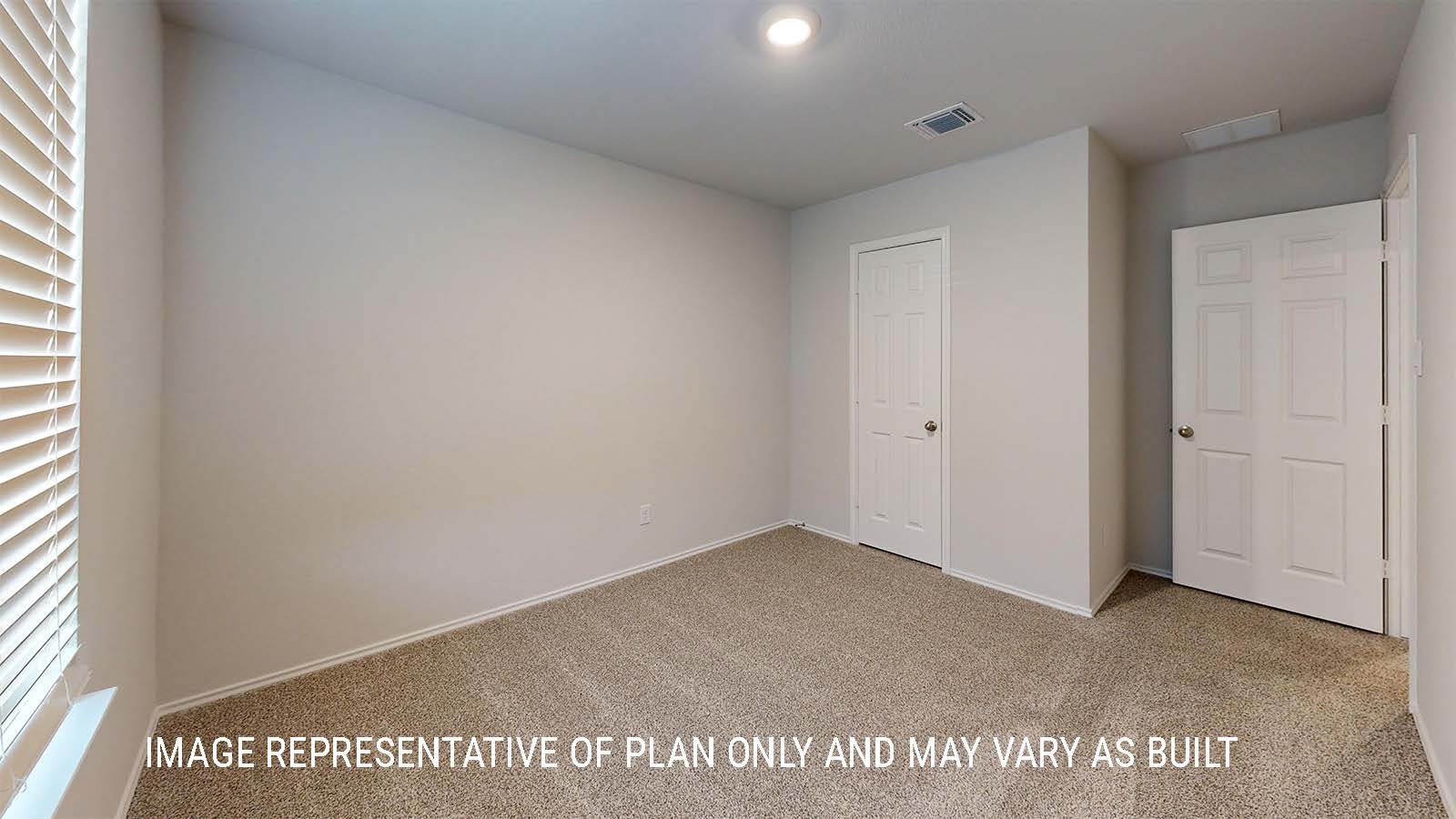 Grace secondary bedroom with carpeted flooring and closet door.
