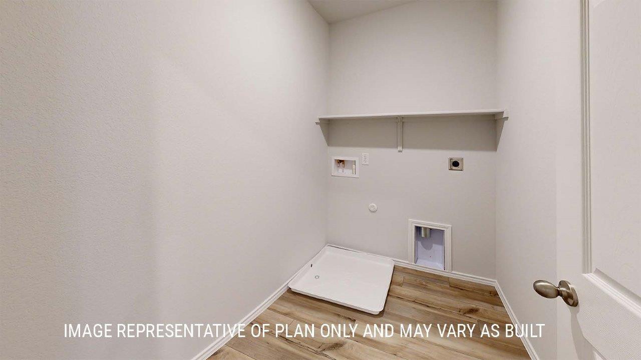 Grace utility room with washer and dryer connections and shelving for storage.