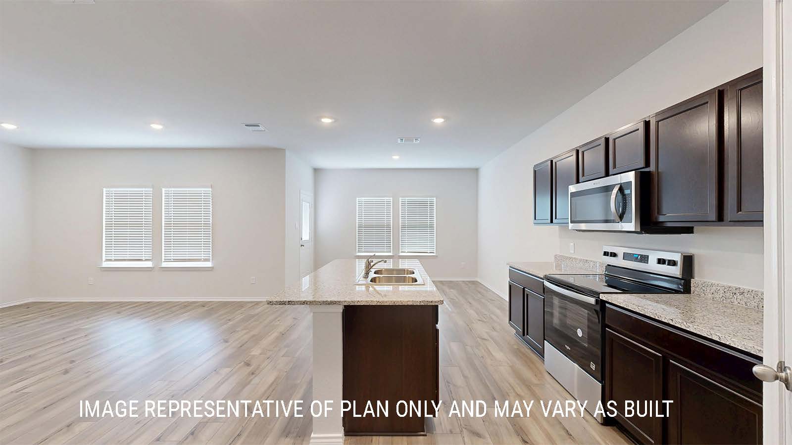 Grace kitchen with dark cabinets and granite countertops.