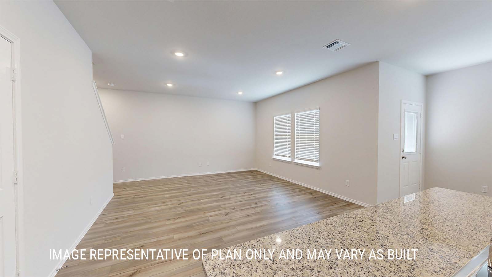 Grace kitchen with center kitchen island with granite countertops and view of open concept living room.