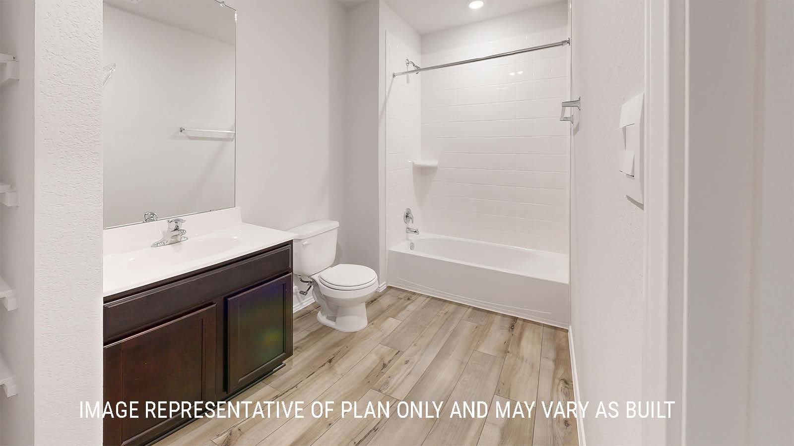 Grace secondary bathroom with single vanity with dark cabinets and a shower and tub combo.