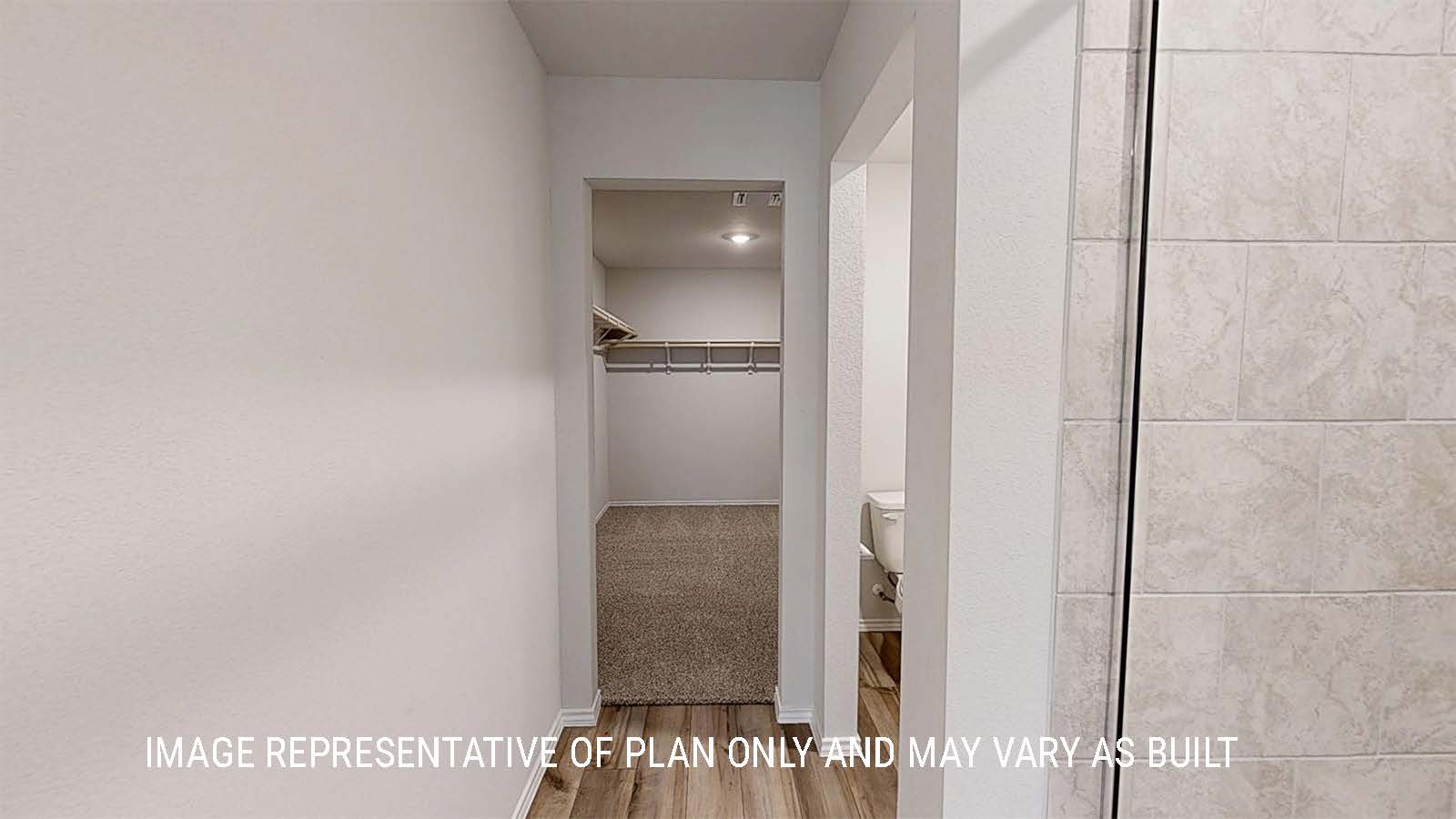 Grace primary bathroom with walk-in shower and view of the primary closet.