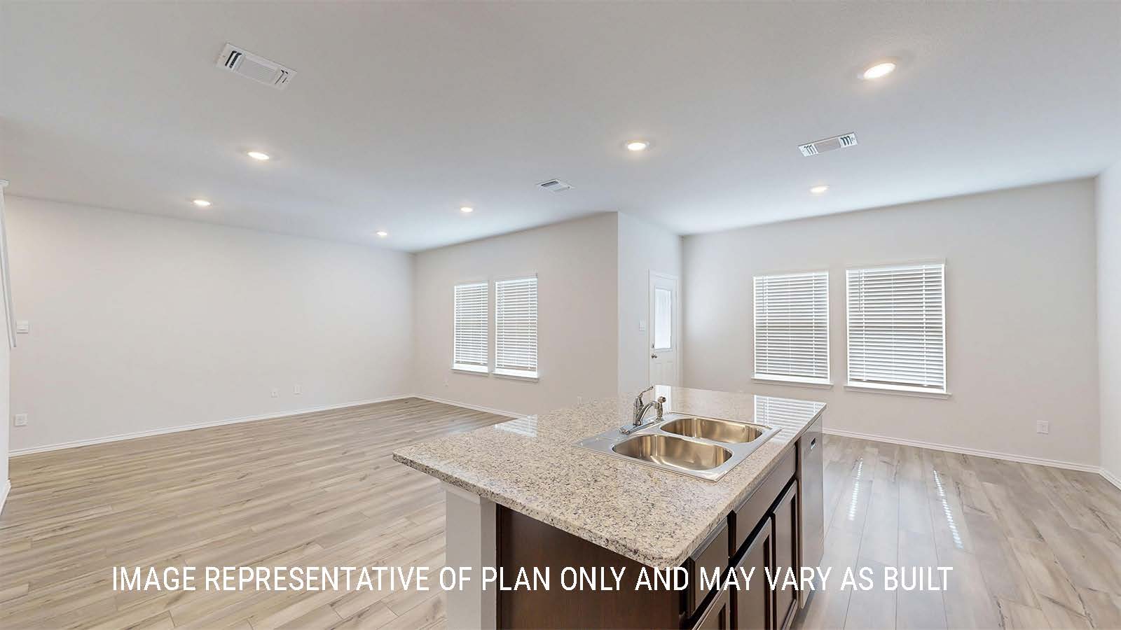 Grace kitchen with center kitchen island with granite countertops and view of open concept living room and dining room.