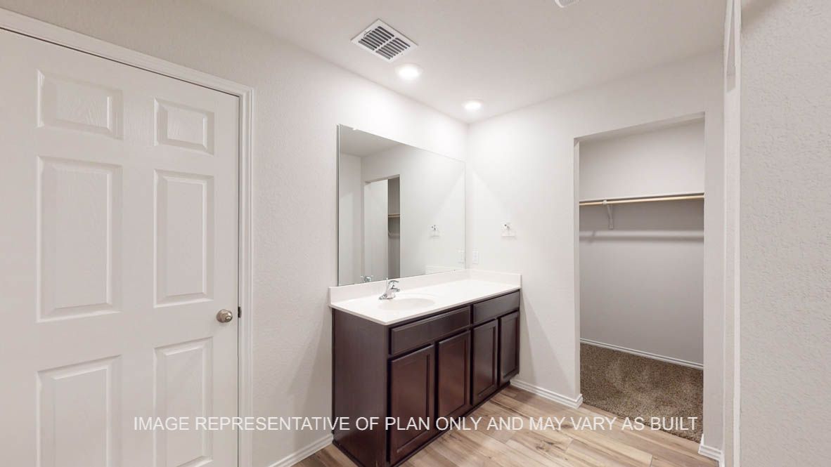 Abbot primary bathroom with vanity sink and view of primary closet.