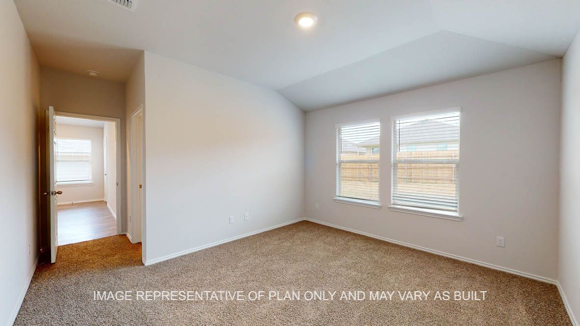 Abbot primary bedroom with carpet flooring and windows.