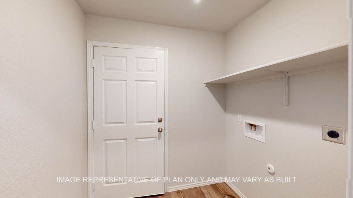 Abbot utility room with washer and dryer connections and shelving for storage.