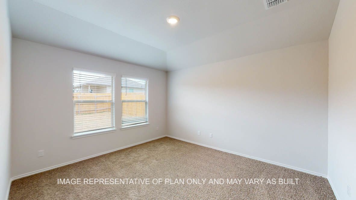 Abbot primary bedroom with carpet flooring and windows.
